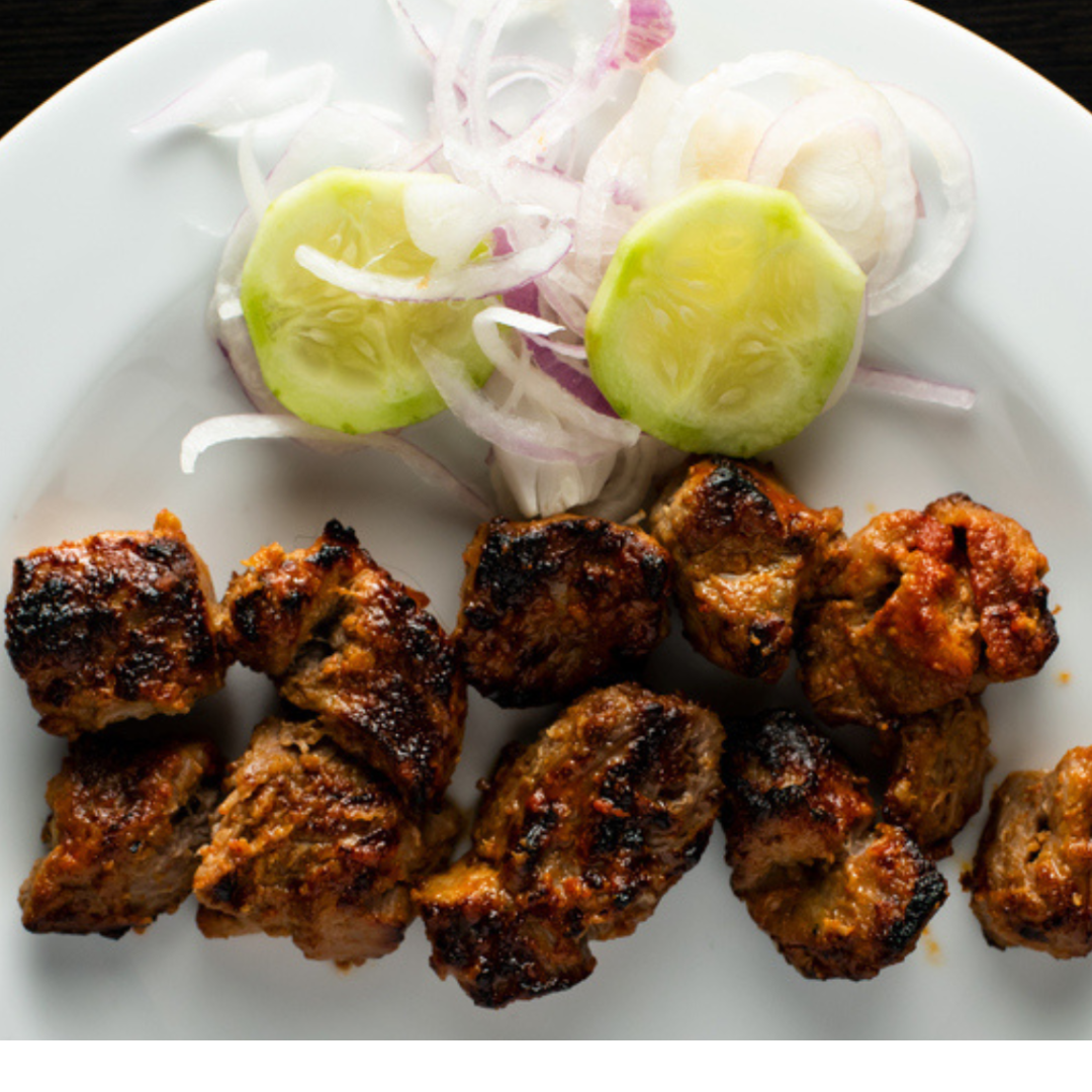 Authentic North Indian lamb tikka skewers with charred edges, served with a simple cucumber and onion salad.